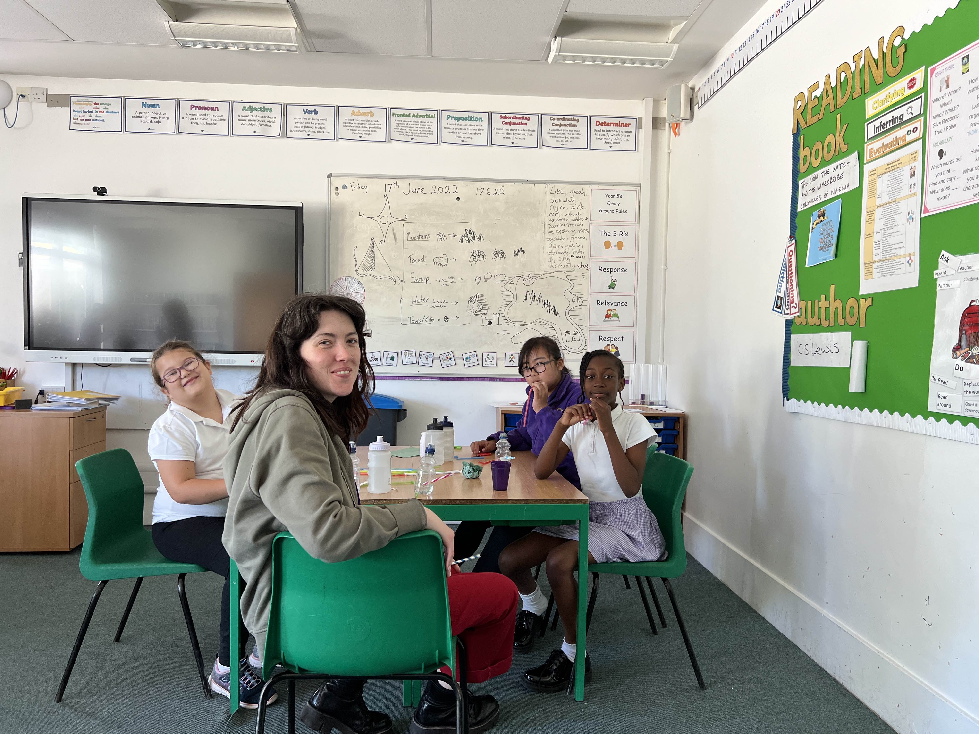 This image shows one teacher and three Year 4 and Year 5 schoolchildren from Ashford Oaks Primary School in Ashford Kent smiling at the camera. 