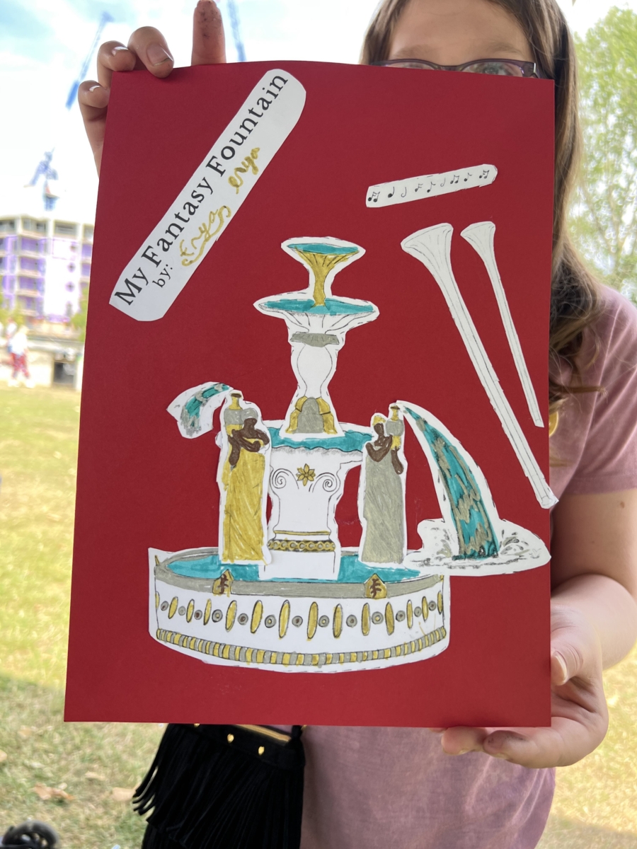 This image shows a child holding a finished 'Create your own Fantasy Fountain' game. She made it on the premiere day of Fantasy Fountain in Victoria Park, 2022. It shows a fountain with long horns coming out.